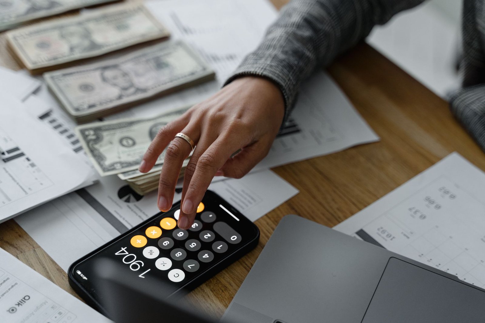 Hands calculating VA retroactive back pay with forms and a calculator