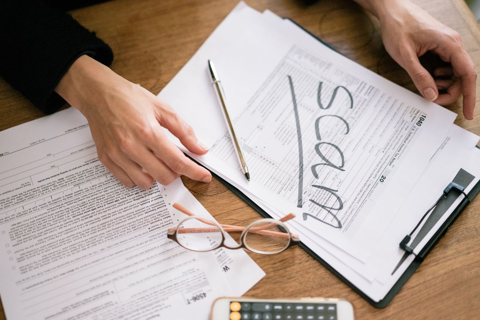 Hands completing application forms for Social Security survivor benefits and DIC