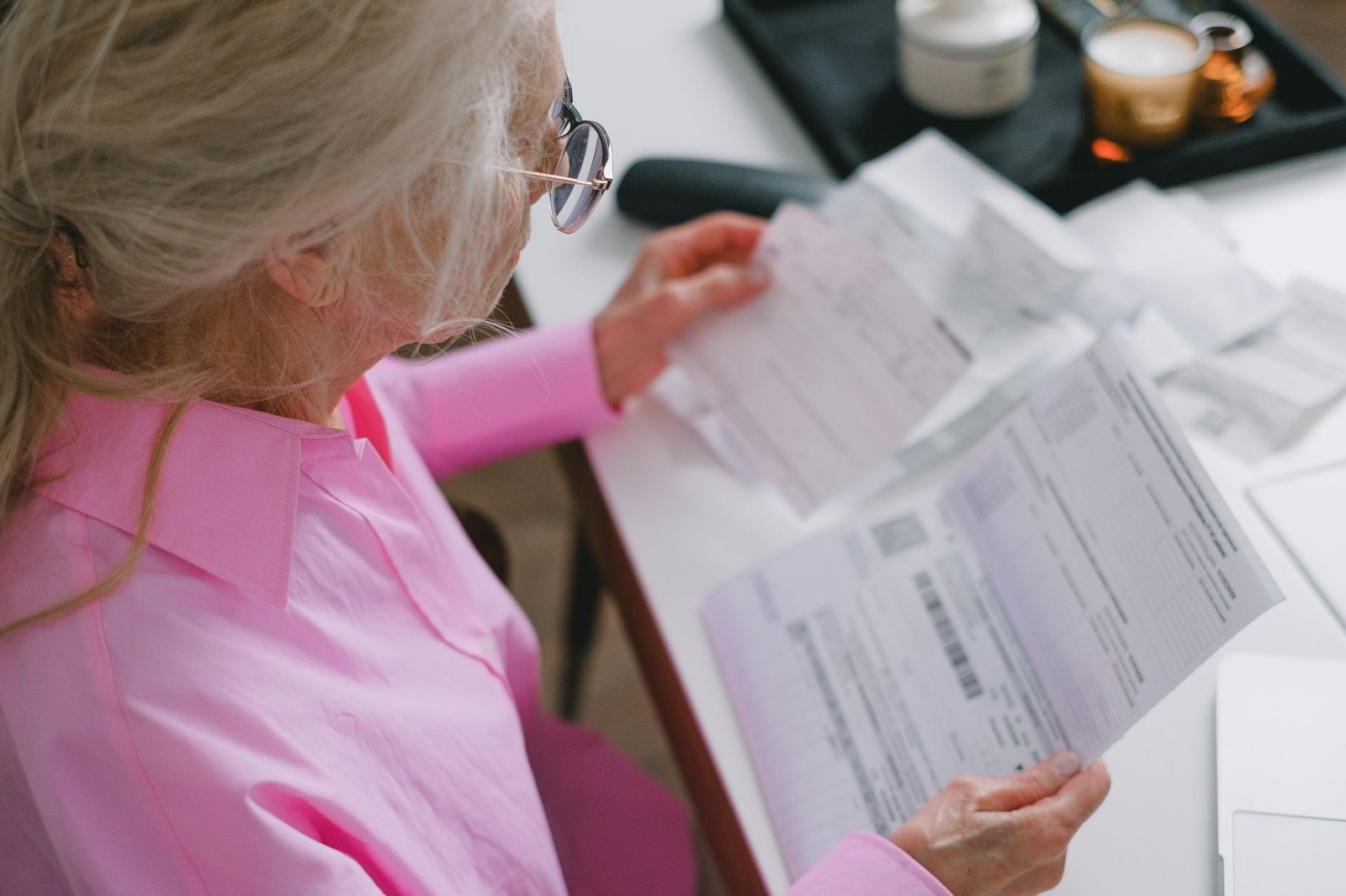 Older veteran organizing military records for VA claims at his desk at home