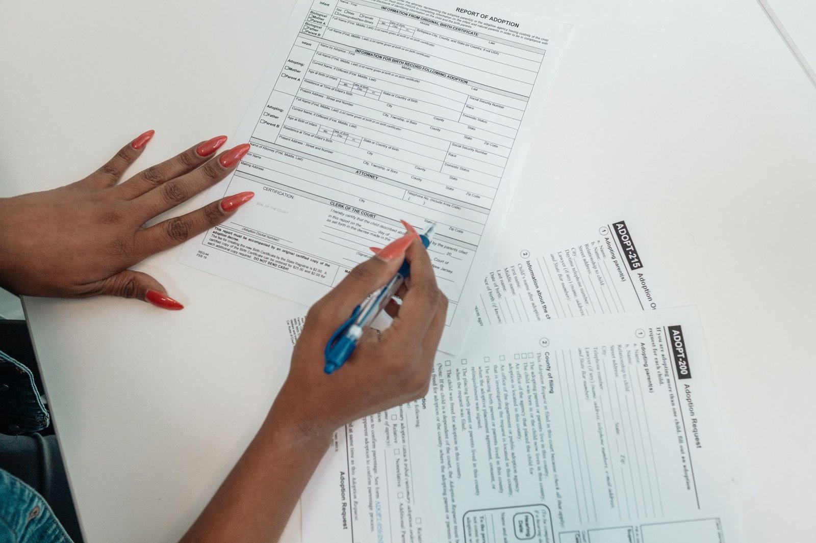 Hands completing the VA clothing allowance form at a home desk